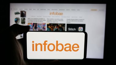 Stuttgart, Almanya - 05-27-2025: Arjantin online gazetesi Infobae 'nin logosunun bulunduğu cep telefonu web sayfası önünde ekranda. Telefon ekranına odaklan.