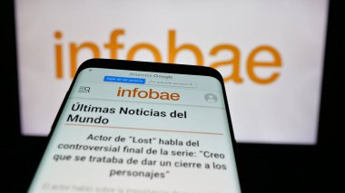 Stuttgart, Almanya - 05-27-2025: Arjantin online gazetesi Infobae 'nin web sitesi ile birlikte logo önünde cep telefonu. Telefon ekranının sol üst kısmına odaklan.