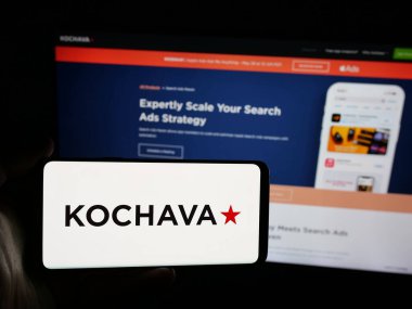 Stuttgart, Almanya - 05-29-2025: İnternet sitesinin önünde ekranda ABD 'li veri çözümleri şirketi Kochava Inc.' in logosuna sahip akıllı telefonu tutan kişi. Telefon ekranına odaklan.