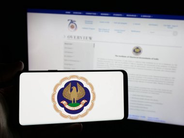 Stuttgart, Almanya - 05-29-2025: Tüzük Muhasebeciler Enstitüsü (ICAI) logosuna sahip akıllı telefonu web sitesi önünde ekranda tutan kişi. Telefon ekranına odaklan.