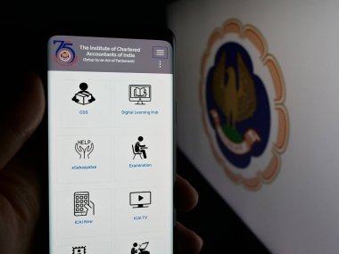 Stuttgart, Almanya - 05-29-2025: Tüzük Muhasebeciler Enstitüsü 'nün (ICAI) web sayfası logonun önünde duran kişi. Telefon ekranının merkezine odaklan.