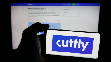 Stuttgart, Almanya - 05-29-2025: İnternet sayfasının önünde üzerinde bağlantı yönetim platformu logosu bulunan cep telefonu sahibi kişi Cutt.ly ekranda. Telefon ekranına odaklan.