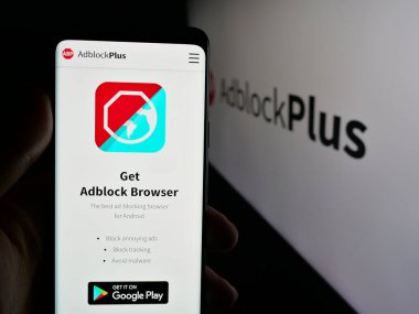 Stuttgart, Almanya - 05-29-2025: Reklam engelleme şirketi Adblock Plus 'ın (eyo GmbH) web sayfası logonun önünde duran kişi. Telefon ekranının merkezine odaklan.