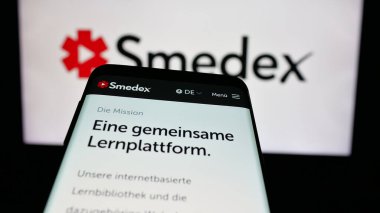 Stuttgart, Almanya - 05-29-2025: İsviçre 'nin e-öğrenim şirketi Smedex AG' nin web sitesiyle birlikte cep telefonu logonun önünde ekranda. Telefon ekranının sol üst kısmına odaklan.