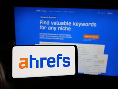 Stuttgart, Almanya - 05-29-2025: SEO alet şirketi Ahrefs Pte 'nin logosunu taşıyan kişi. Ltd. Web sitesinin önünde ekranda. Telefon ekranına odaklan.