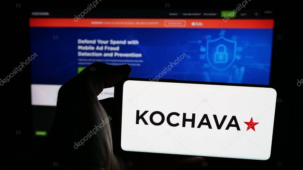 Stuttgart, Germany - 05-29-2025: Person holding mobile phone with logo of US data solutions company Kochava Inc. on screen in front of web page. Focus on phone display.