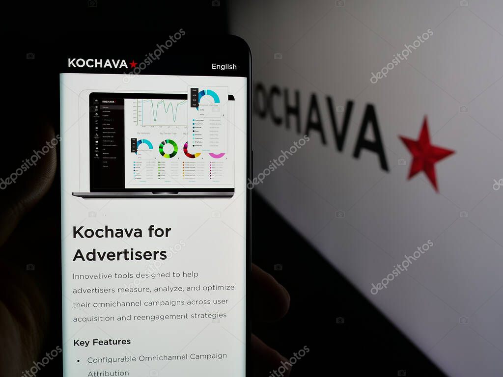 Stuttgart, Germany - 05-29-2025: Person holding cellphone with webpage of US data solutions company Kochava Inc. on screen in front of logo. Focus on center of phone display.