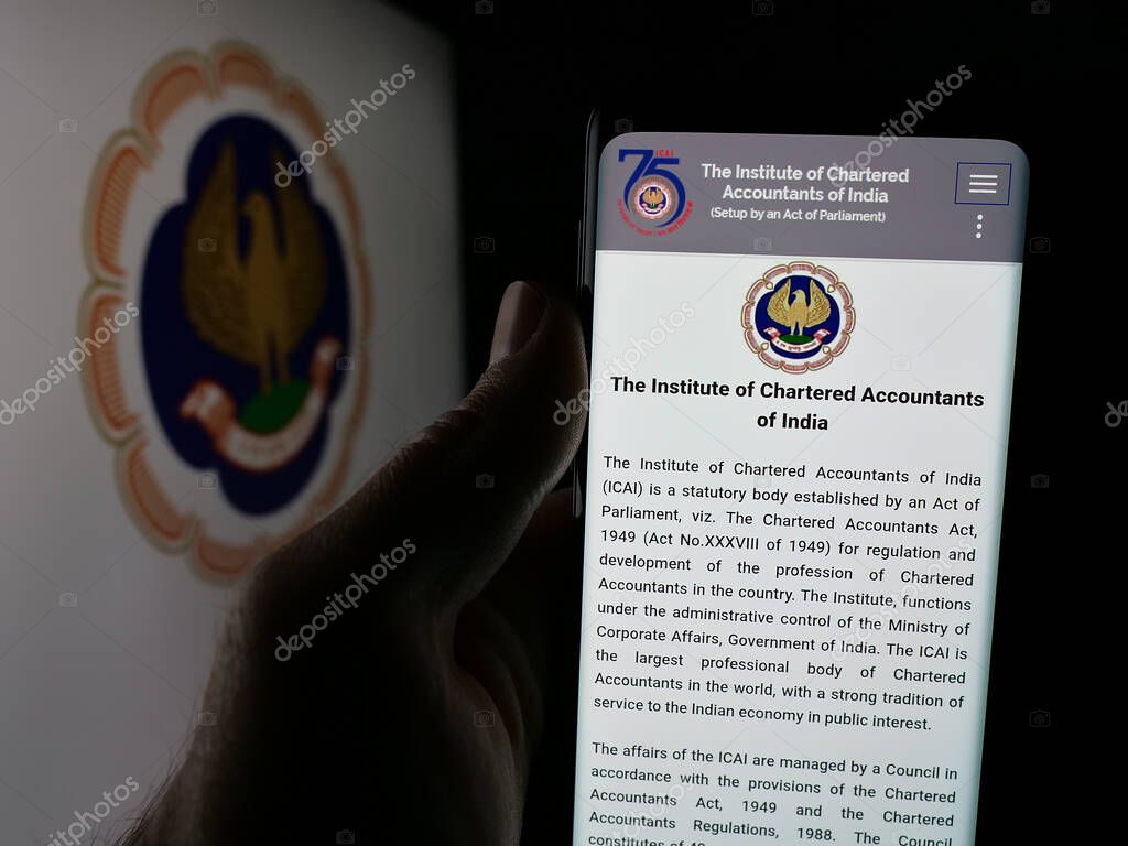 Stuttgart, Germany - 05-29-2025: Person holding cellphone with webpage of Institute of Chartered Accountants (ICAI) on screen in front of logo. Focus on center of phone display.