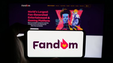 Stuttgart, Almanya - 05-31-2025: İnternet sayfası önünde ABD wiki hizmet şirketi Fandom Inc. 'in logosuyla cep telefonu tutan kişi. Telefon ekranına odaklan.