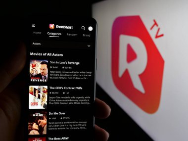 Stuttgart, Almanya - 05-31-2025: Kısa video yayınlama uygulaması şirketi ReelShort 'un web sayfası olan cep telefonu logonun önünde ekranda. Telefon ekranının merkezine odaklan.