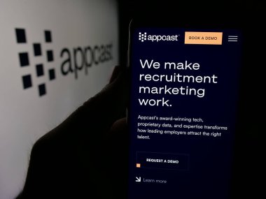 Stuttgart, Almanya - 05-31-2025: İşe alım teknolojileri şirketi Appcast Inc. 'in web sayfası ile akıllı telefon sahibi kişi logonun önünde ekranda. Telefon ekranının merkezine odaklan.