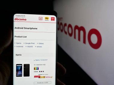 Stuttgart, Almanya - 05-31-2025: Telekomünikasyon şirketi NTT Docomo Inc. 'in web sayfası olan cep telefonu logonun önünde ekranda. Telefon ekranının merkezine odaklan.