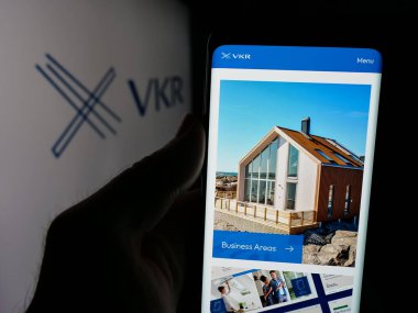 Stuttgart, Almanya - 05-31-2025: Danimarkalı yatırım şirketi VKR Holding AS 'in web sayfası ile akıllı telefon sahibi kişi logonun önünde ekranda. Telefon ekranının merkezine odaklan.