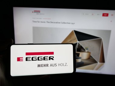 Stuttgart, Almanya - 05-31-2025: Avusturyalı şirket Egger Holzwerkstoffe GmbH 'nin logosunu taşıyan kişi web sitesinin önünde ekranda. Telefon ekranına odaklan.