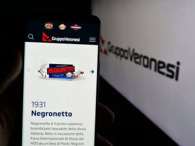 Stuttgart, Almanya - 05-31-2025: İtalyan gıda şirketi Veronesi Holding S.P.A 'nın internet sayfası ile akıllı telefon taşıyan kişi logonun önünde ekranda. Telefon ekranının merkezine odaklan.