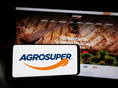 Stuttgart, Almanya - 06-01-2025: Şilili gıda şirketi Agrosuper S.A. 'nın logosunu elinde tutan kişi web sitesinin önünde ekranda. Telefon ekranına odaklan.