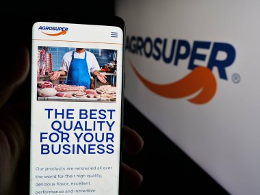 Stuttgart, Almanya - 06-01-2025: Şilili gıda şirketi Agrosuper S.A. 'nın web sayfası ile akıllı telefonu olan kişi logonun önünde ekranda. Telefon ekranının merkezine odaklan.