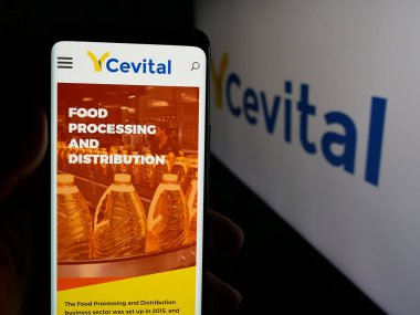 Stuttgart, Almanya - 06-02-2025: Cezayirli şirket Cevital Group 'un internet sayfası logonun önünde duran kişi. Telefon ekranının merkezine odaklan.