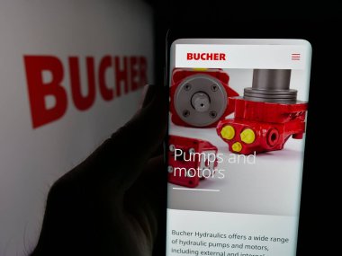 Stuttgart, Almanya - 06-02-2025: İsviçreli makine şirketi Bucher Industries AG 'nin web sayfası ile akıllı telefon sahibi kişi logonun önünde ekranda. Telefon ekranının merkezine odaklan.