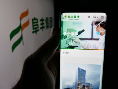 Stuttgart, Almanya - 06-02-2025: Çinli kimya şirketi Fufeng Group Ltd. 'nin web sayfası ile akıllı telefon sahibi kişi logonun önünde ekranda. Telefon ekranının merkezine odaklan.