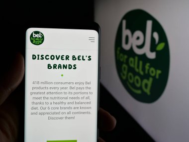 Stuttgart, Almanya - 06-02-2025: Fransız peynir şirketi Groupe Bel 'in web sitesi ile akıllı telefon sahibi kişi logonun önünde ekranda. Telefon ekranının merkezine odaklan.