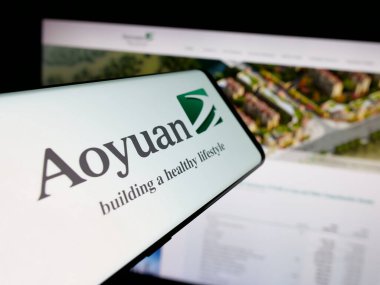 Stuttgart, Almanya - 06-02-2025: Mülk şirketi Aoyuan Group Limited 'in logosuna sahip akıllı telefon web sitesinin önünde ekranda. Telefon ekranının merkez sağına odaklan.