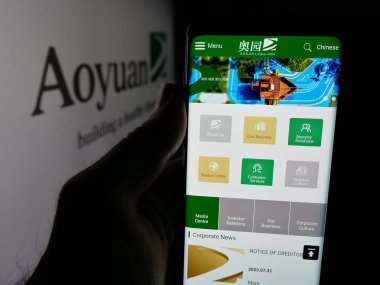 Stuttgart, Almanya - 06-02-2025: Mülk şirketi Aoyuan Group Limited 'in web sayfası ile akıllı telefon sahibi kişi logo önünde ekranda görülüyor. Telefon ekranının merkezine odaklan.