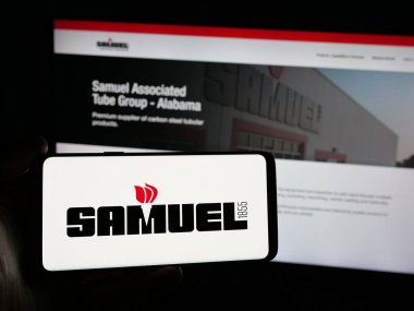 Stuttgart, Almanya - 06-02-2025: Metal işleme şirketi Samuel Son Co. Inc. 'nin logosunu elinde tutan kişi web sitesinin önünde ekranda. Telefon ekranına odaklan.
