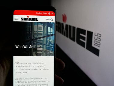 Stuttgart, Almanya - 06-02-2025: Metal işleme şirketi Samuel Son Co. 'nun web sayfası ile cep telefonu sahibi kişi logonun önünde ekranda. Telefon ekranının merkezine odaklan.