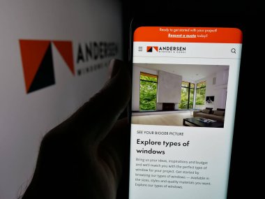 Stuttgart, Almanya - 06-04-2025: ABD 'li pencere şirketi Andersen Corporation' ın web sayfası ile akıllı telefon sahibi kişi logonun önünde ekranda. Telefon ekranının merkezine odaklan.