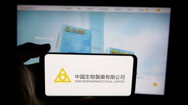 Stuttgart, Almanya - 06-04-2025: Sino Biyofarmasötik (Biopharm) logosu olan cep telefonu sahibi kişi web sayfası önünde ekranda. Telefon ekranına odaklan.
