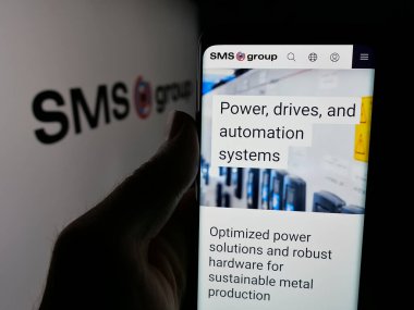 Stuttgart, Almanya - 06-04-2025: Alman mühendislik şirketi GmbH 'nin web sayfası ile akıllı telefonu logo önünde ekranda tutan kişi. Telefon ekranının merkezine odaklan.