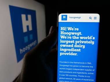 Stuttgart, Almanya - 06-04-2025: Hollandalı mandıra şirketi Hoogwegt Groep B.V. 'nin web sayfası ile akıllı telefon taşıyan kişi logonun önünde ekranda. Telefon ekranının merkezine odaklan.