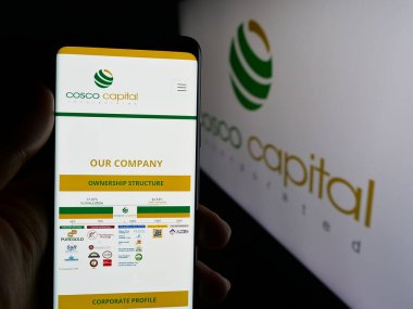 Stuttgart, Almanya - 06-04-2025: Yatırım şirketi Cosco Capital Inc. 'in web sayfası logonun önünde duran kişi. Telefon ekranının merkezine odaklan.