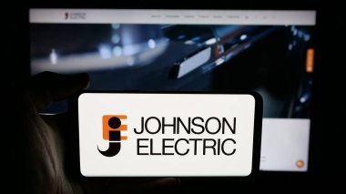 Stuttgart, Almanya - 06-04-2025: Cep telefonunda Johnson Electric Holding Limited şirketinin logosu olan kişi web sayfasının önünde ekranda. Telefon ekranına odaklan.