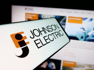 Stuttgart, Almanya - 06-04-2025: İnternet sitesi önünde ekranda Johnson Electric Holding Limited şirketinin logosuna sahip akıllı telefon. Telefon ekranının merkez soluna odaklan.