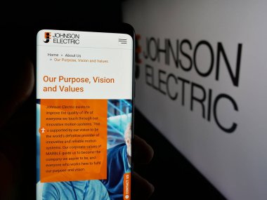Stuttgart, Almanya - 06-04-2025: Johnson Electric Holding Limited şirketinin internet sayfası olan cep telefonu logosu önünde ekranda. Telefon ekranının merkezine odaklan.
