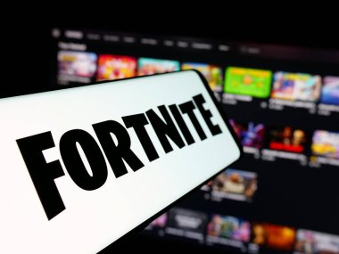 Stuttgart, Almanya - 06-05-2025: İnternet sitesinin önünde Fortnite oyun platformunun logosuna sahip akıllı telefon. Telefon ekranının merkez soluna odaklan.