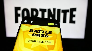 Stuttgart, Almanya - 06-05-2025: Mobil telefon çevrimiçi oyun platformu Fortnite 'in web sitesi logonun önünde ekranda. Telefon ekranının sol üst kısmına odaklan.