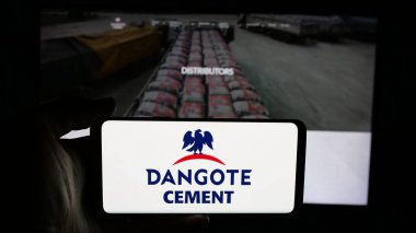 Stuttgart, Almanya - 06-05-2025: Nijeryalı malzeme şirketi Dangot Çimento 'nun logosunun bulunduğu cep telefonu web sayfası önünde ekranda. Telefon ekranına odaklan.