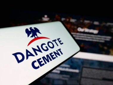Stuttgart, Almanya - 06-05-2025: İnternet sitesinin önünde üzerinde Nijeryalı malzeme şirketi Dangote Cement plc 'nin logosu bulunan akıllı telefon. Telefon ekranının merkez soluna odaklan.