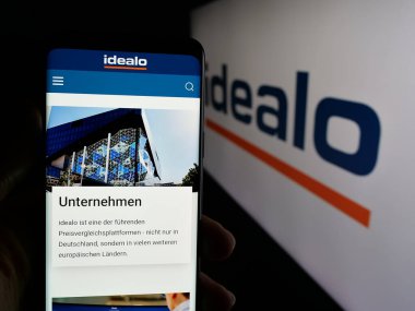 Stuttgart, Almanya - 06-05-2025: Logo önündeki ekranda, fiyat karşılaştırma şirketi idealo Internet GmbH 'nin web sayfası ile akıllı telefon tutan kişi. Telefon ekranının merkezine odaklan.