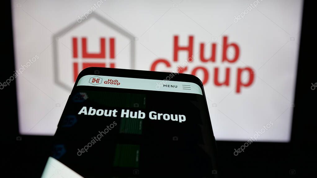Stuttgart, Germany - 05-31-2025: Mobile phone with website of US logistics company Hub Group Inc. on screen in front of logo. Focus on top-left of phone display.