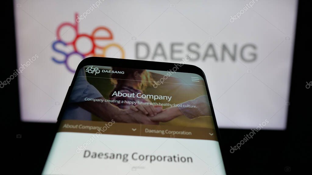 Stuttgart, Germany - 06-01-2025: Mobile phone with website of Korean food company Daesang Holdings Co. Ltd. on screen in front of logo. Focus on top-left of phone display.