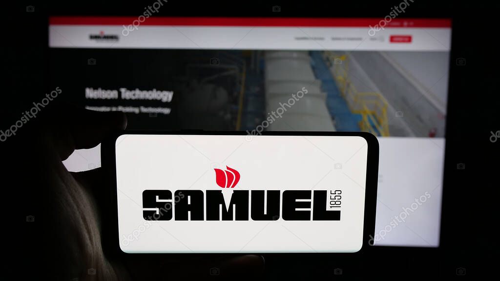 Stuttgart, Germany - 06-02-2025: Person holding cellphone with logo of metal processing company Samuel Son Co. Inc. on screen in front of webpage. Focus on phone display.