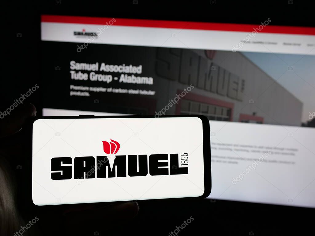 Stuttgart, Germany - 06-02-2025: Person holding smartphone with logo of metal processing company Samuel Son Co. Inc. on screen in front of website. Focus on phone display.