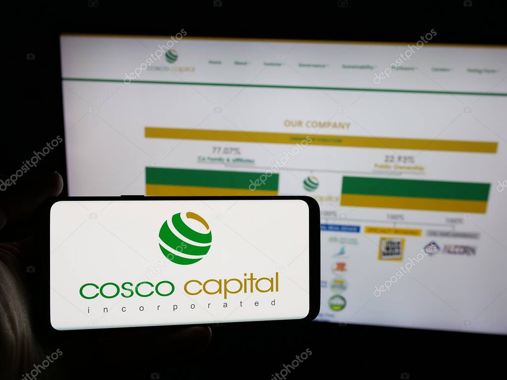 Stuttgart, Germany - 06-04-2025: Person holding smartphone with logo of investment company Cosco Capital Inc. on screen in front of website. Focus on phone display.