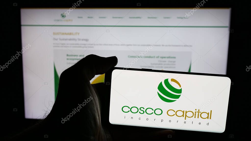 Stuttgart, Germany - 06-04-2025: Person holding mobile phone with logo of investment company Cosco Capital Inc. on screen in front of web page. Focus on phone display.