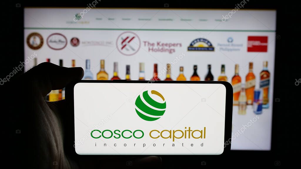 Stuttgart, Germany - 06-04-2025: Person holding cellphone with logo of investment company Cosco Capital Inc. on screen in front of webpage. Focus on phone display.