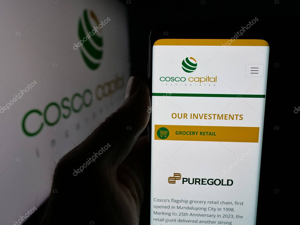 Stuttgart, Germany - 06-04-2025: Person holding smartphone with web page of investment company Cosco Capital Inc. on screen in front of logo. Focus on center of phone display.